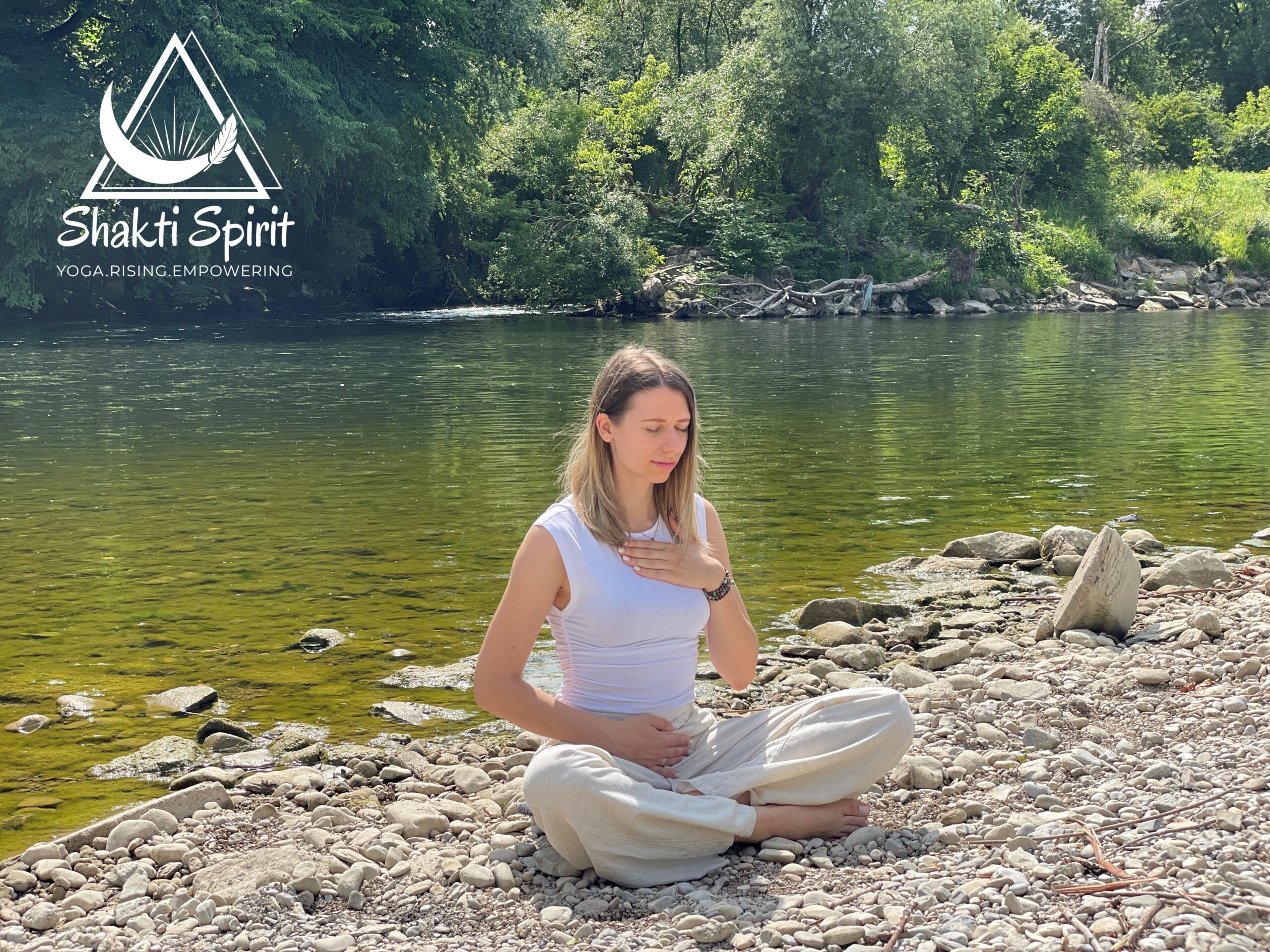 Frau sitzt in Meditationshaltung am Fluss